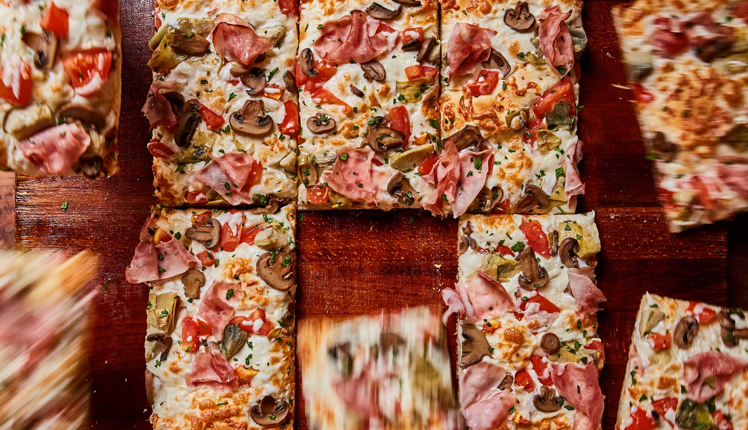 Slices of pizza sit on top of wood surface